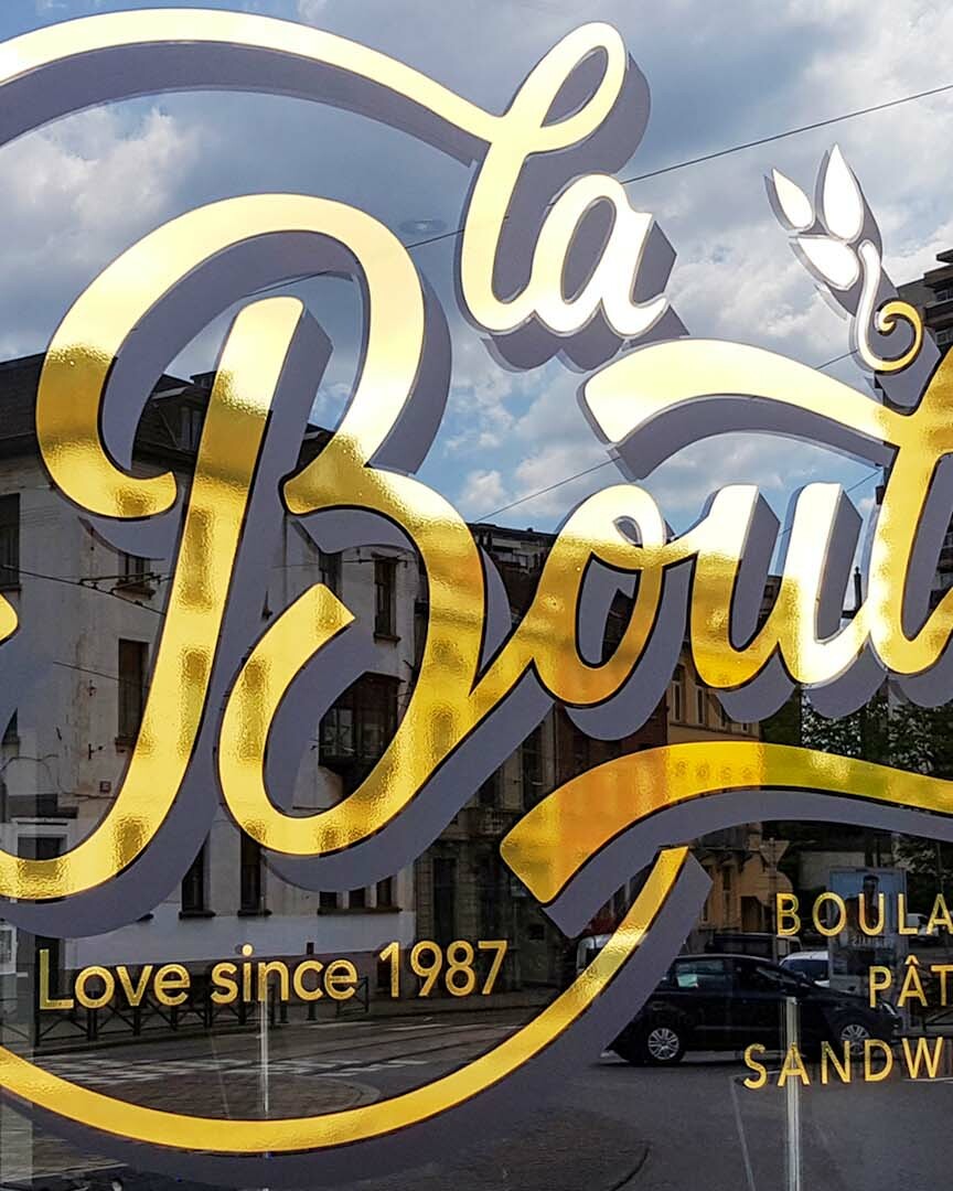 Vitrophanie et lettrage adhésif sur vitrines réalisés par Belmont Atelier.